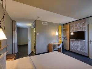 a hotel room with a bed and a desk at ibis Zürich City West in Zurich