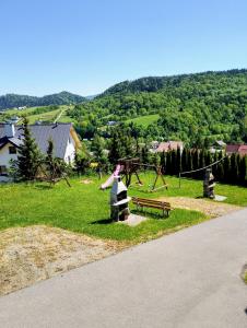 a park with a playground with a bench and a swing at Domek Bieszczady Wolkowyja 2 nad Solina in Wołkowyja +10 photos