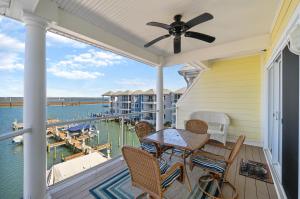 a porch with a ceiling fan and a table and chairs at Sunset Bay Villa 309 - Changes in Latitude in Chincoteague