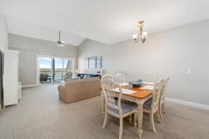a dining room with a table and chairs and a couch at Sunset Bay Villa 309 - Changes in Latitude in Chincoteague