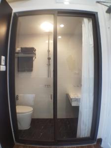 a bathroom with a toilet and a glass shower door at Tung Trang Hotel in Hanoi
