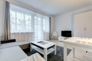 a white living room with a couch and a table at Apartament Gdańsk Sun and Sea in Gdańsk