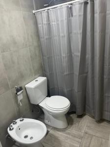 a bathroom with a toilet and a shower curtain at Depto temporal in Morón