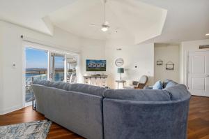 a large blue couch in a living room with a window at Sunset Bay Villa 313 - By the Bay in Chincoteague
