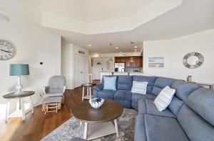 a living room with a blue couch and a table at Sunset Bay Villa 313 - By the Bay in Chincoteague
