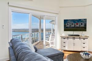 a living room with a couch and a view of the ocean at Sunset Bay Villa 313 - By the Bay in Chincoteague +45 photos