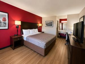 a hotel room with a bed and a flat screen tv at Sunset Inn in Jacksonville +5 photos