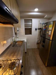 a kitchen with a stainless steel refrigerator and a sink at Fly At Home Bogotá in Bogotá