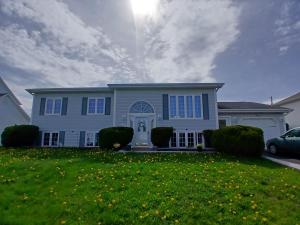 a white house with a car parked in front of it at Home Away From Home in Moncton