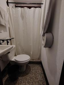 a white bathroom with a toilet and a sink at Hotel Sueño Real in Panajachel +50 photos