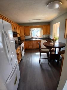 a kitchen with a table and a white refrigerator at Home Away From Home in Moncton