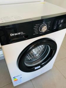 a white washing machine with a black door at Hibis Gold in Cayenne