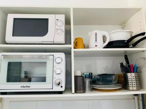 a microwave oven sitting on top of a kitchen shelf at Hibis Gold in Cayenne +4 photos
