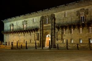 a large stone building with an arch in front of it at Parador de Santiago - Hostal Reis Catolicos in Santiago de Compostela