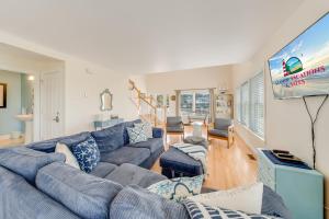 a living room with a blue couch and a flat screen tv at The Baywatch Bungalow in Greenbackville