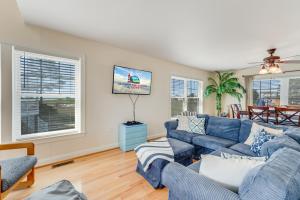 a living room with a blue couch and a tv at The Baywatch Bungalow in Greenbackville