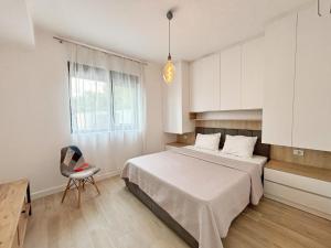 a bedroom with a bed and a chair and a window at Modern Garden House in Tivat