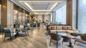 a waiting room with couches and tables and chairs at Crowne Plaza Rugao in Nantong