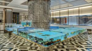 a lobby with a large aquarium with blue water at Crowne Plaza Rugao in Nantong
