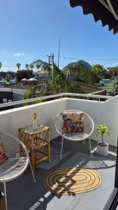 a patio with two chairs and a table on a balcony at Miro St Guest House in Mount Maunganui
