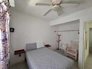 a bedroom with a bed and a ceiling fan at Departamento Playa Linda in Barrio Nuevo +15 photos