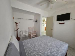 a bedroom with a bed and a flat screen tv at Departamento Playa Linda in Barrio Nuevo
