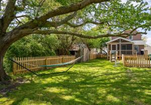 a yard with a fence and a hammock under a tree at The Mane Escape in Chincoteague