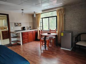 a kitchen with a table and chairs in a room at Casa y Flores in Baños