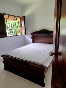 a bedroom with a bed and a window at Milflora casa completa in Nuquí