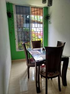 a dining room with a table and chairs and a window at Milflora casa completa in Nuquí