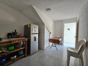 a kitchen with a refrigerator and a table and a chair at Departamento Playa Linda in Barrio Nuevo
