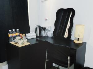 a black desk with a chair and a lamp at My Room Sri Aman in Kampong Lamanak