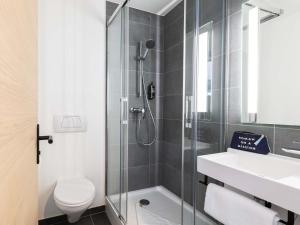 a bathroom with a shower and a toilet and a sink at ibis Strasbourg Centre Gare in Strasbourg +51 photos