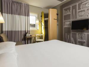 a hotel room with a bed and a tv at ibis Leicester in Leicester