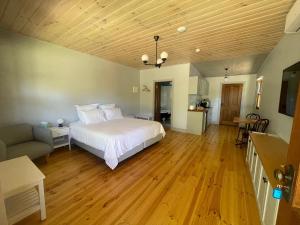 ein großes Schlafzimmer mit einem weißen Bett und einem Sofa in der Unterkunft Tread Lightly Willunga Cabins in Willunga
