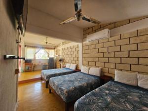 a room with three beds and a brick wall at Departamento El Dorado in Barrio Nuevo