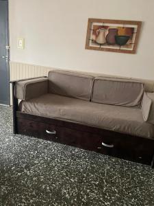 a brown couch in a room with a wall at Doñalola in General Alvear