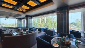 a restaurant with blue chairs and tables and windows at Hotel skyline by RK in Tinsukia +1 photo
