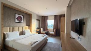 a hotel room with a bed and a flat screen tv at Hotel skyline by RK in Tinsukia