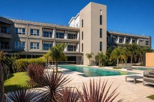 a building with a swimming pool in front of a building at Radisson Red Funes in Rosario
