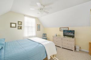 a bedroom with a blue bed and a tv at The Sweets Spot in Greenbackville