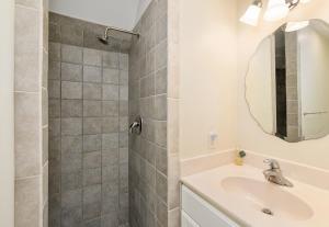 a bathroom with a sink and a shower with a mirror at The Sweets Spot in Greenbackville