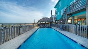 a swimming pool next to a building next to the ocean at Laguna Sunset by AvantStay in Corpus Christi