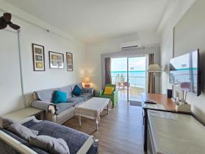 a living room with a couch and a tv at Paradise by the Sea in Penang by Veron at Rainbow Paradise in Tanjung Bungah