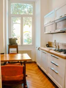 a kitchen with a wooden table and a table and a window at Sanremo Apartments - Orchidea in Sanremo