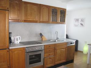 a kitchen with wooden cabinets and a stove top oven at Haus am Dorfplatz in Uttendorf