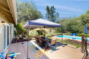 a patio with a table and an umbrella next to a pool at 1 Mi to Lake Tulloch: Home w/ Patio Oasis & Pool in Copper Cove Subdivision
