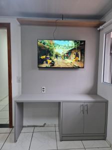 a flat screen tv on a white wall at Condomínio Inn Studio in Foz do Iguaçu +55 photos