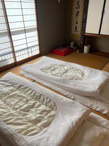 two beds sitting on the floor in a room at 鹿野寒舍館 in Tottori