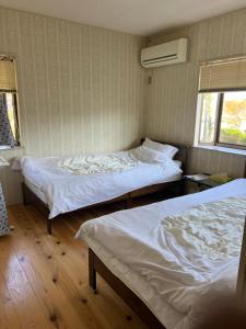 a bedroom with two beds and a window at 鹿野寒舍館 in Tottori +14 photos